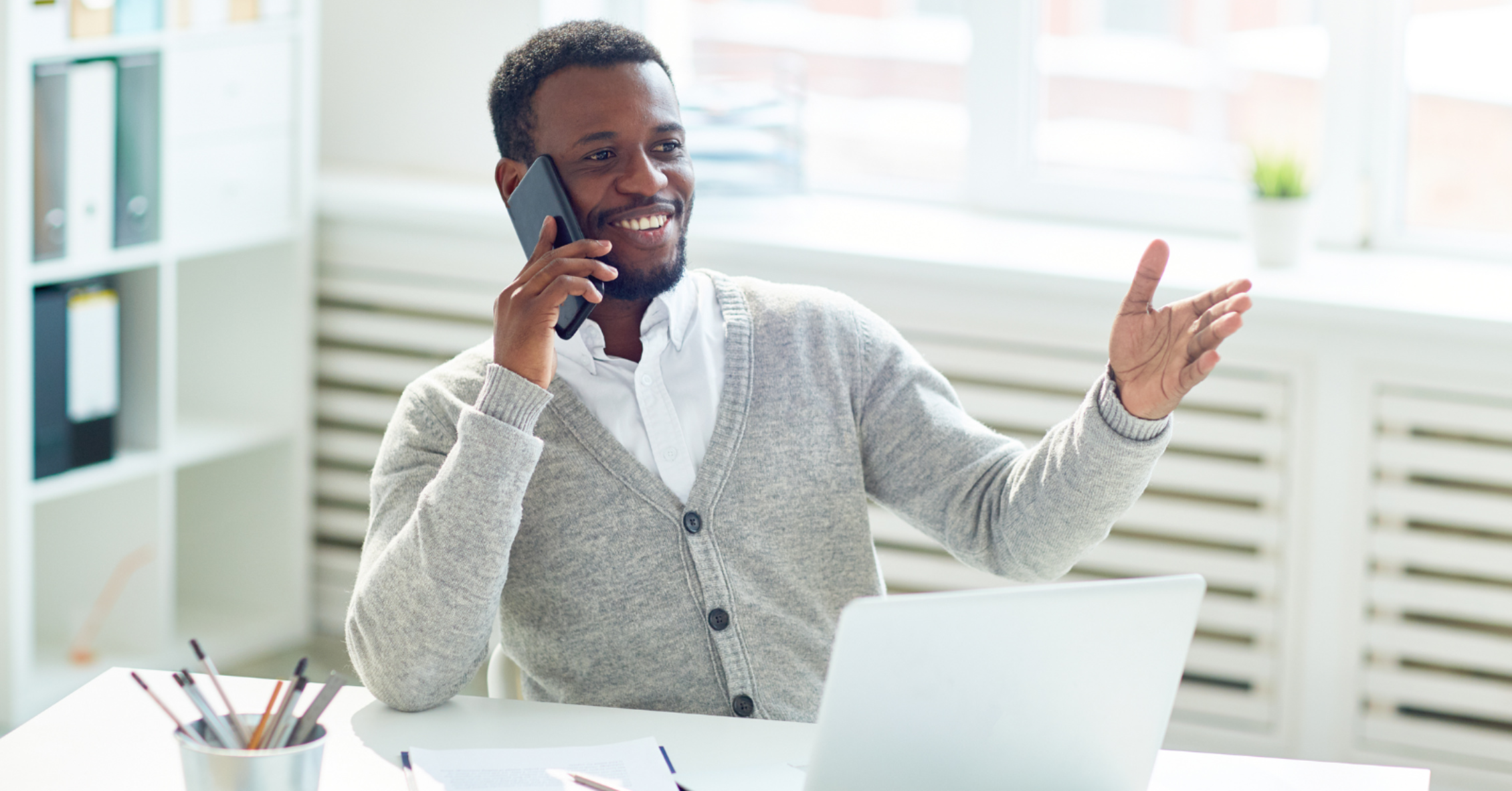 man sitting at desk on phone
