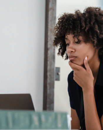 Woman thinking in front of computer